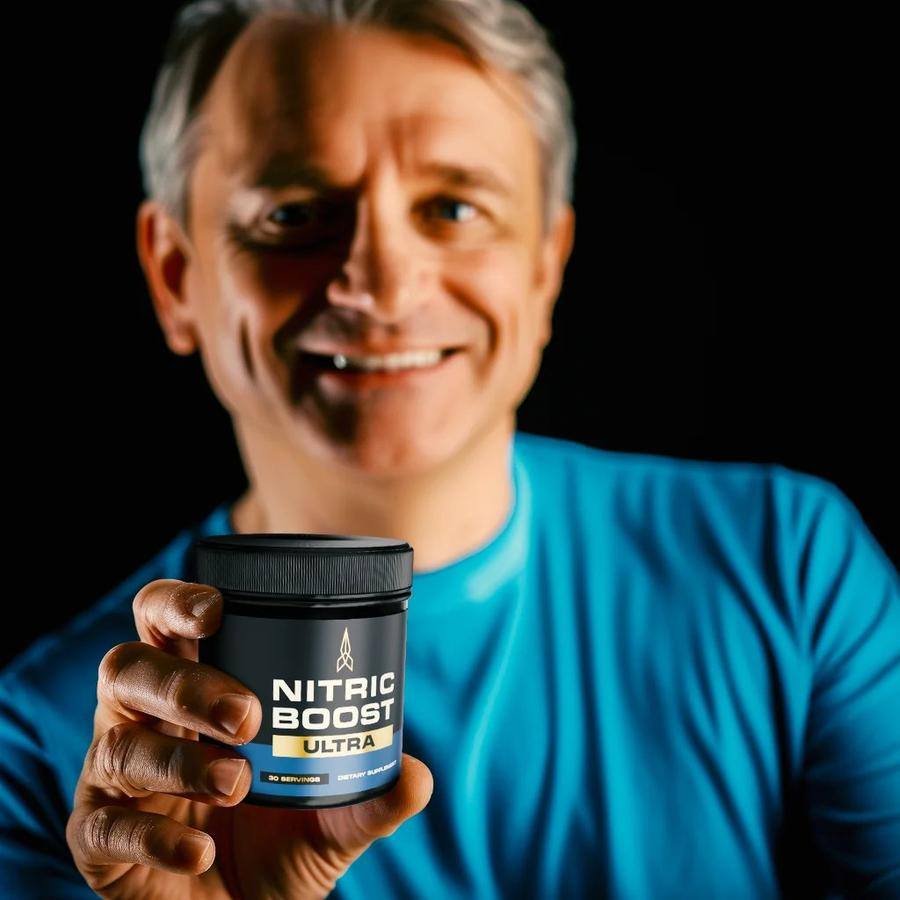 Man holding Nitric Boost Ultra supplement jar
