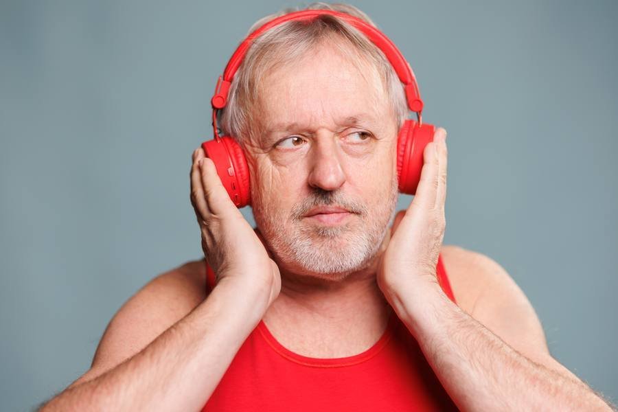 Senior man with headphones — noise exposure is the leading cause of tinnitus