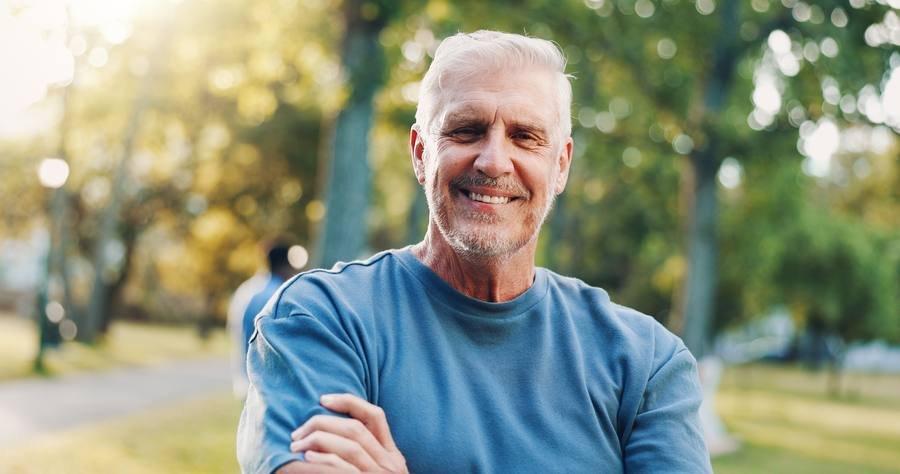 Active senior man smiling confidently outdoors after using nerve health supplement