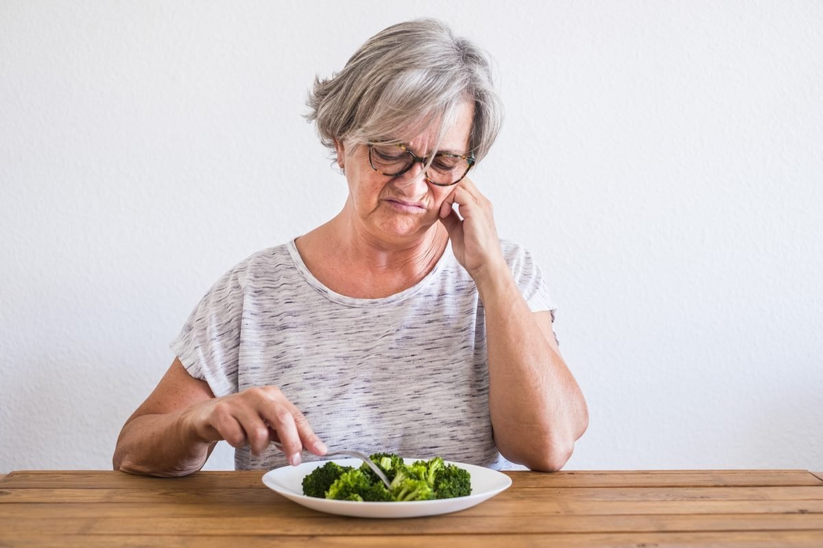 Senior woman feeling fatigued after meal — a common blood sugar warning sign