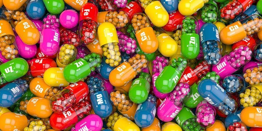 Colorful mineral and vitamin capsules labeled Zn, Mg, Ca — essential nutrients for blood sugar support