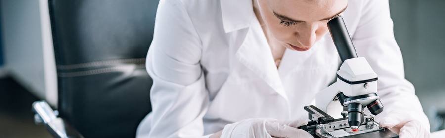 Scientist reviewing nerve health supplement research under microscope in laboratory