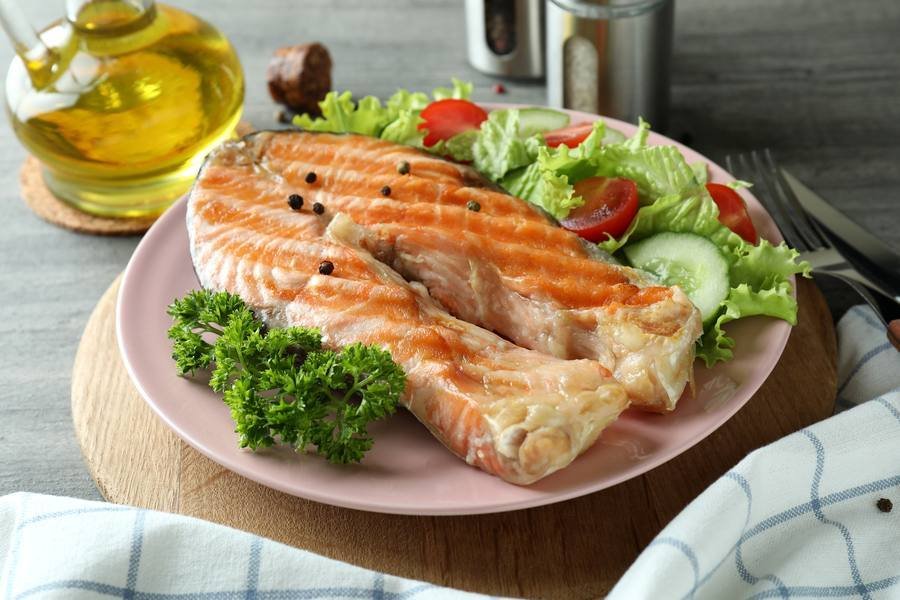 Grilled salmon with salad — omega-3 rich fish is one of the most protective foods for hearing health