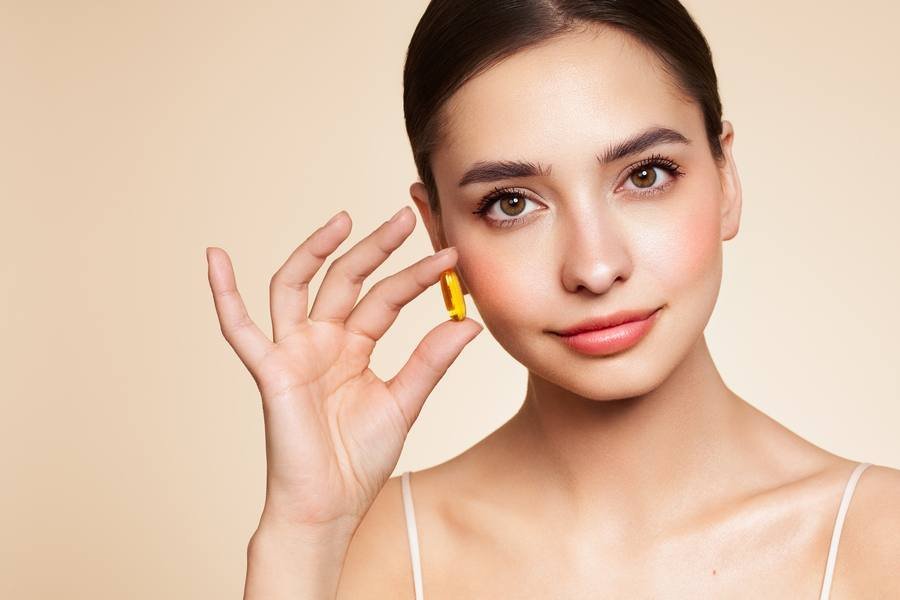 Woman holding vitamin capsule for hearing support