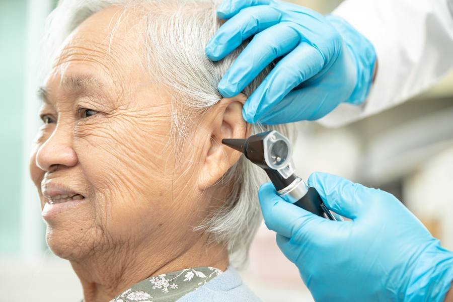 Senior woman receiving ear examination — zinc deficiency is a correctable cause of hearing decline