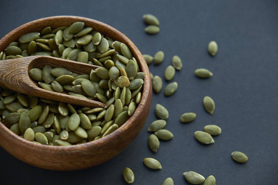 Pumpkin seeds in wooden bowl — one of the richest natural sources of zinc for hearing support