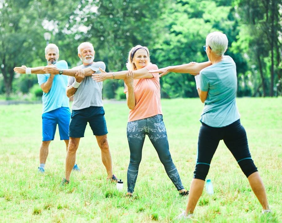 Active seniors exercising outdoors — cardiovascular health is one of the most effective hearing preservation strategies