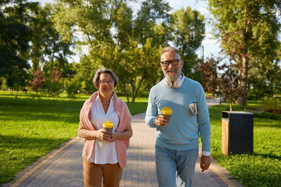 Active senior couple walking outdoors at sunset — staying active supports metabolism after 40